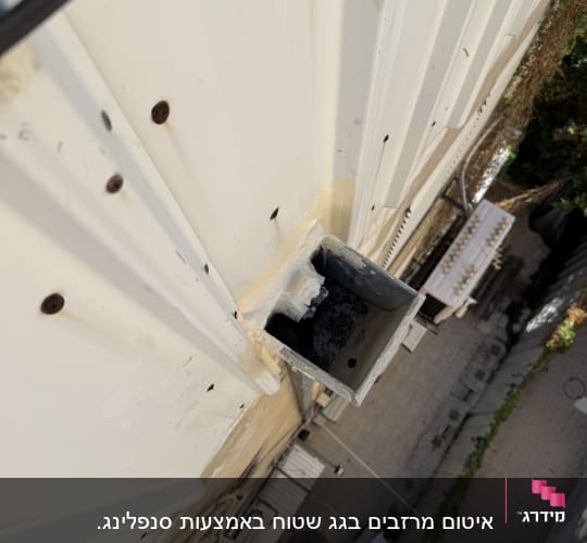 צינור מתכת אטום בחומר איטום על קיר חיצוני